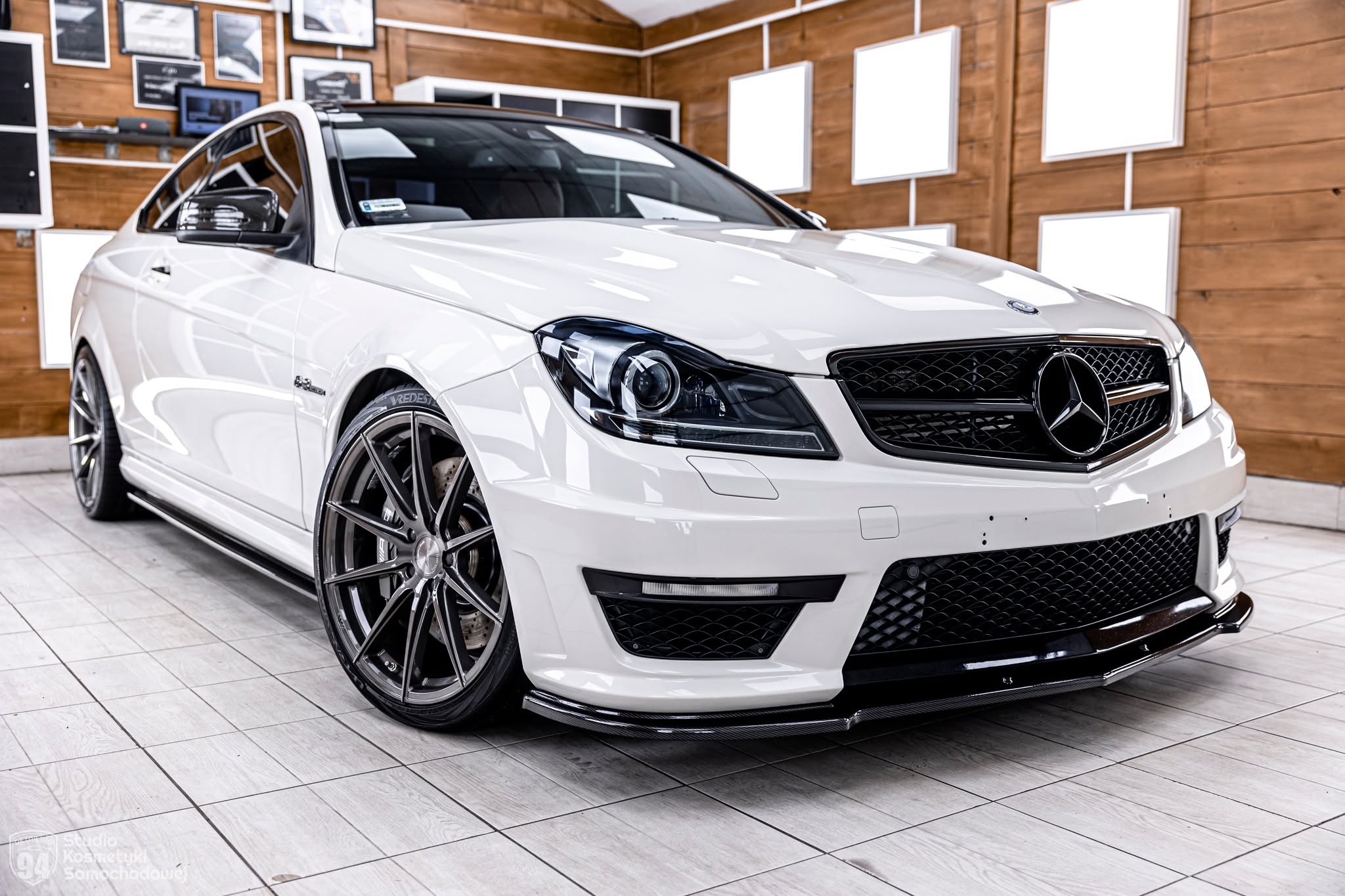 Biały Mercedes-Benz C 63 AMG Coupé W204 po liftingu — widok przodu samochodu